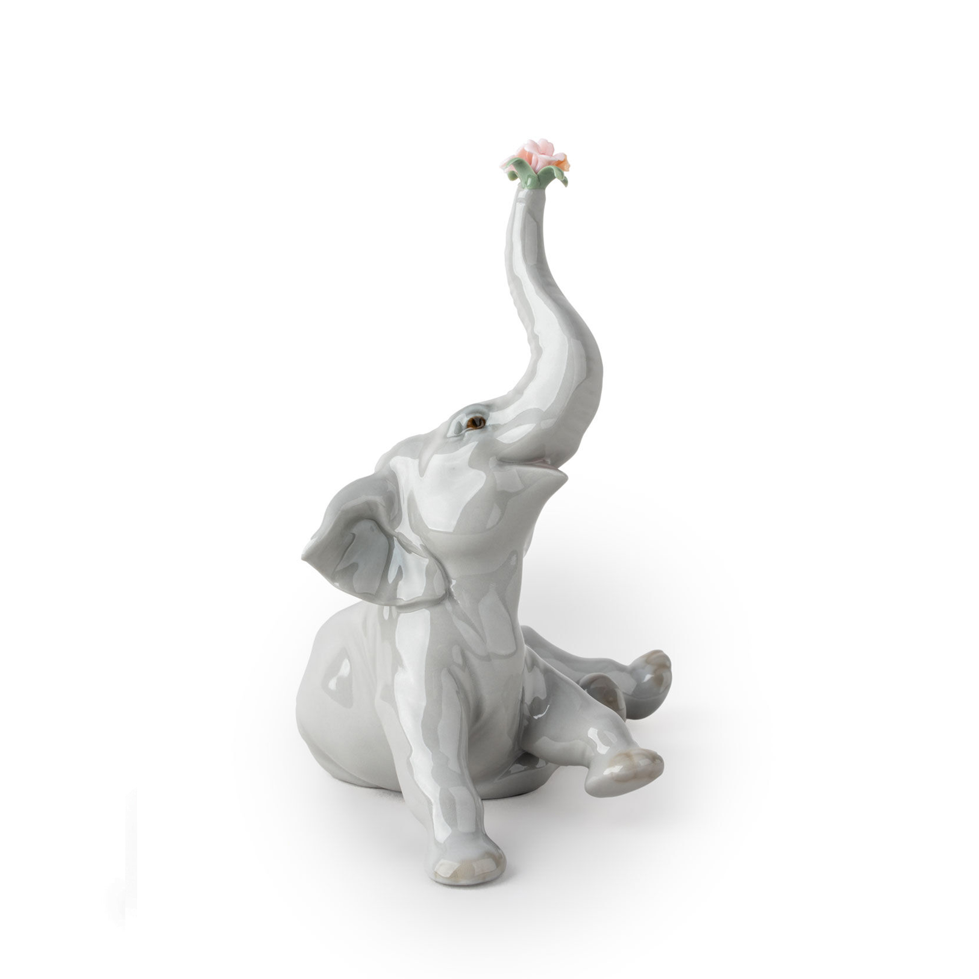 Baby Elephant with Pink Flower Figurine Glossy porcelain animal figurine with baby elephant playing, with a pink flower on her trunk.