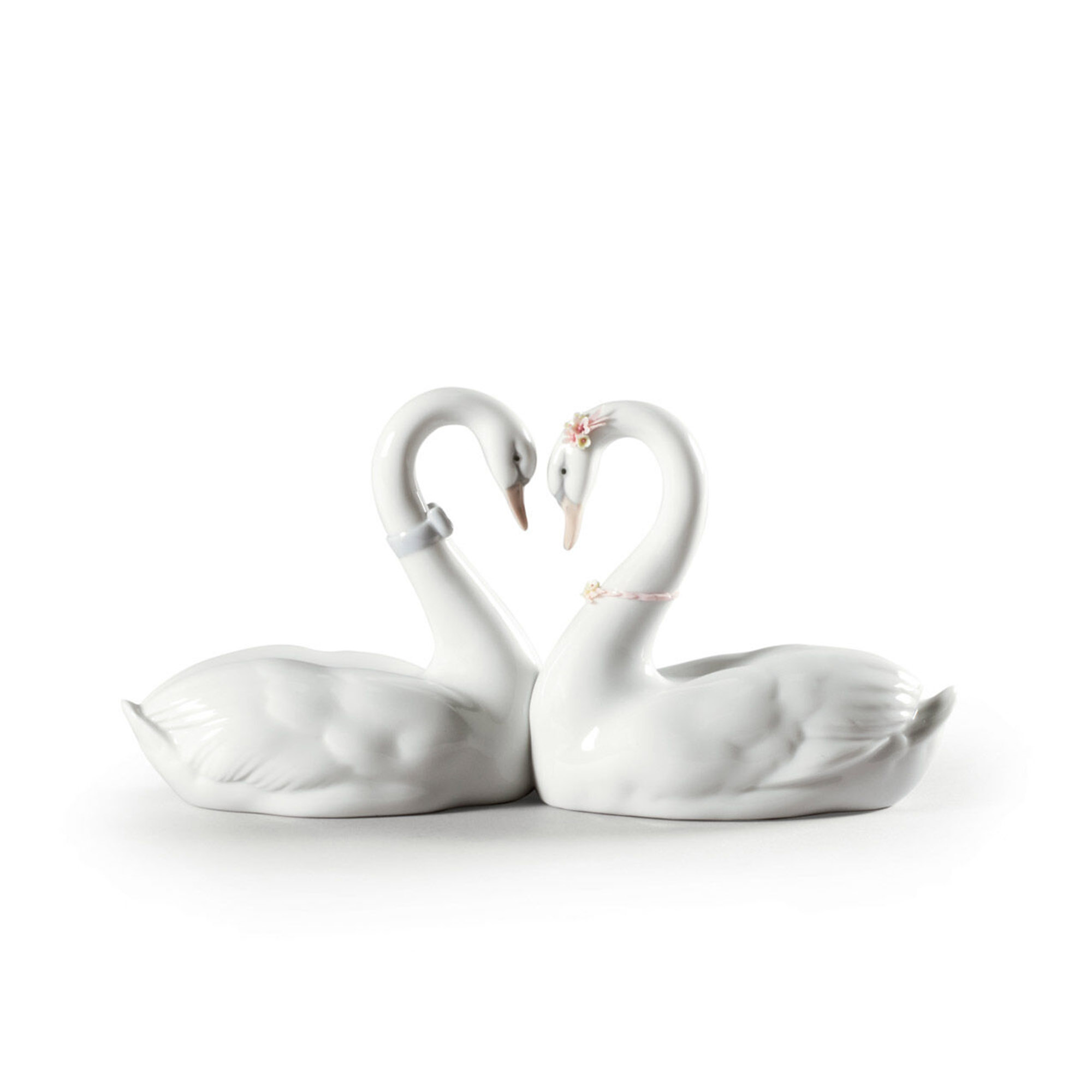 Endless Love Swans. Cake Topper Figurine of two swans with their necks joined together forming a glossy white porcelain heart decorated with flowers and blue ribbon.