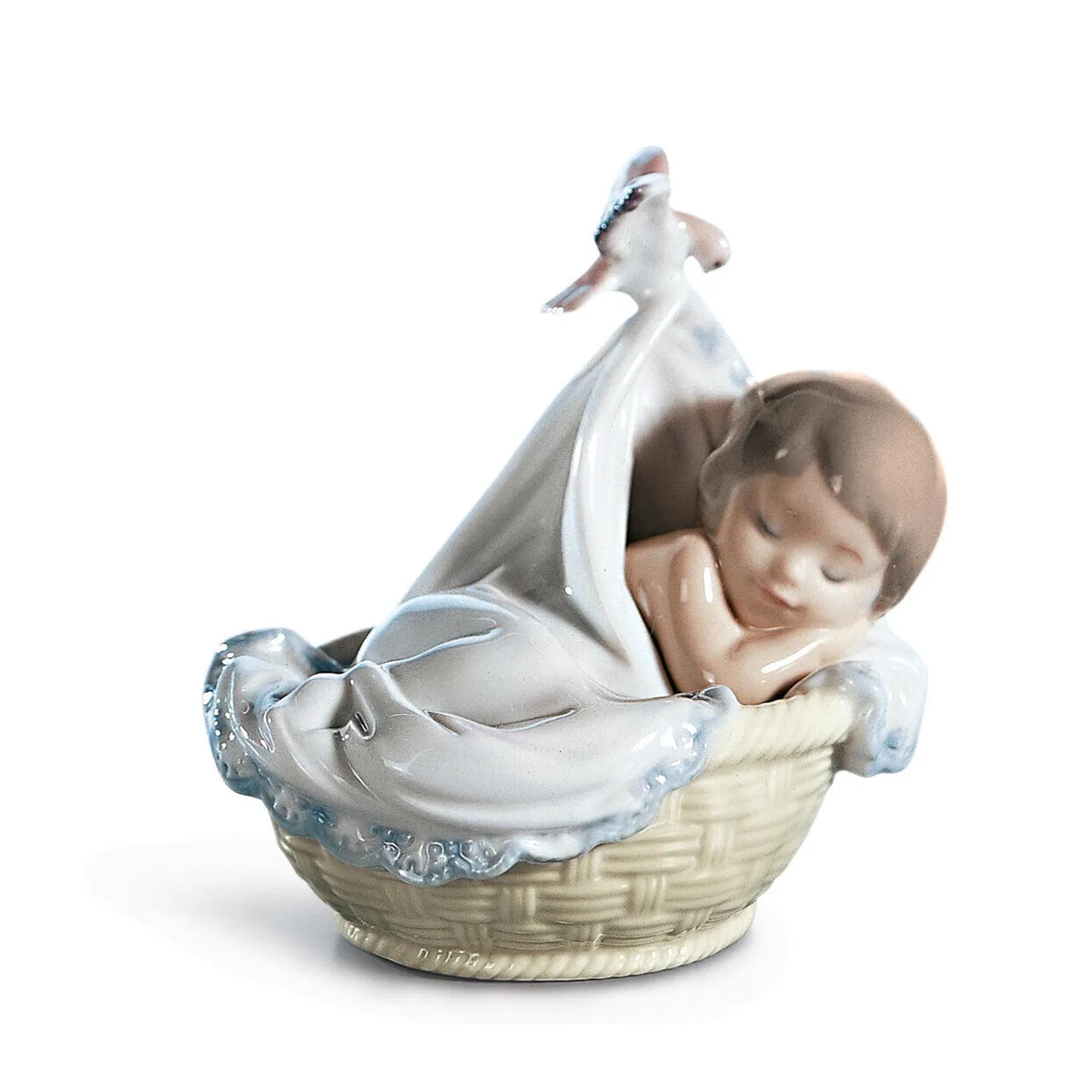 Tender Dreams Boy Figurine Glossy porcelain figurine boy in his crib, wrapped in a white and blue sheet by a small bird.